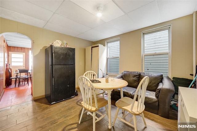 dining area featuring light hardwood / wood-style floors, a paneled ceiling, and a wealth of natural light