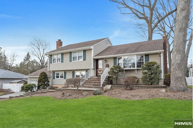 tri-level home featuring a garage and a front yard