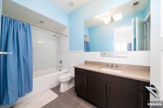 full bathroom with toilet, vanity, tile walls, and shower / bath combination with curtain