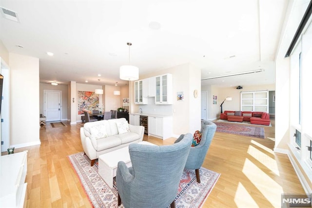 living room with beverage cooler and light hardwood / wood-style floors