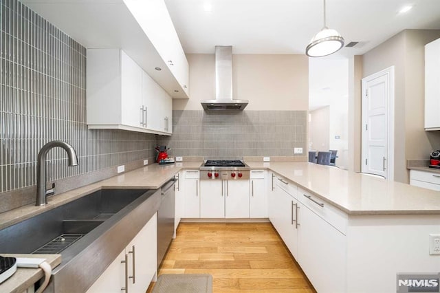 kitchen with sink, extractor fan, white cabinetry, and pendant lighting