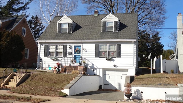 cape cod home with a garage