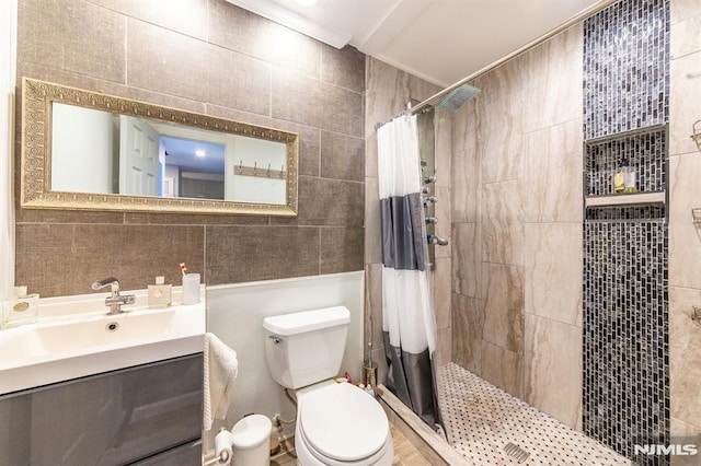 bathroom with tile walls, crown molding, toilet, and walk in shower