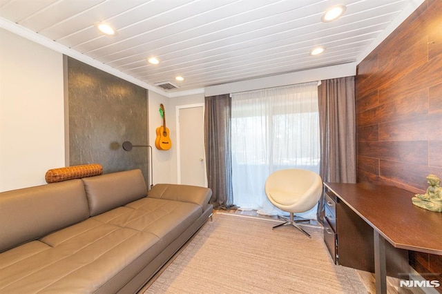 living room with ornamental molding and wooden walls