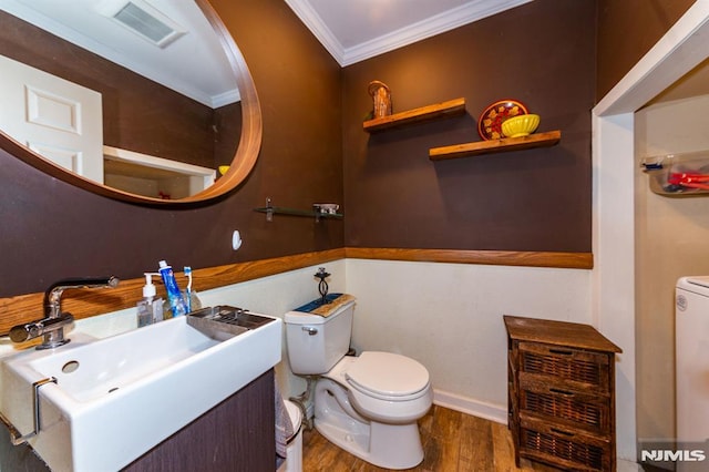 bathroom with ornamental molding, toilet, hardwood / wood-style floors, and vanity