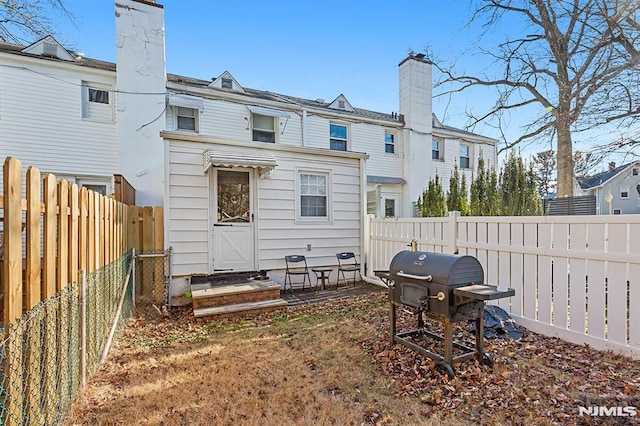 rear view of house featuring a fenced backyard