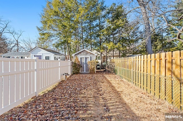 view of yard featuring a fenced backyard, an outdoor structure, and a storage unit