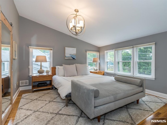 bedroom featuring vaulted ceiling, radiator heating unit, a chandelier, and light hardwood / wood-style floors