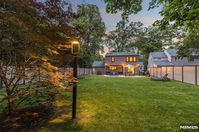 yard at dusk featuring a patio