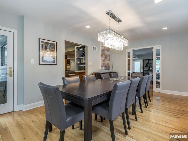 dining room featuring an inviting chandelier and light hardwood / wood-style flooring