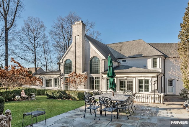 rear view of house with a lawn and a patio area