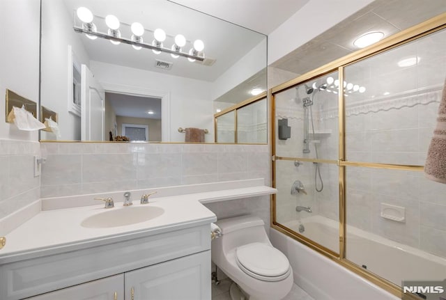 full bathroom with toilet, vanity, tile walls, shower / bath combination with glass door, and tasteful backsplash