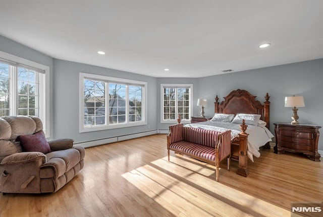 bedroom featuring a baseboard radiator and light hardwood / wood-style flooring