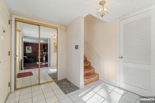 tiled entrance foyer featuring a notable chandelier