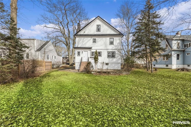 rear view of property with a lawn