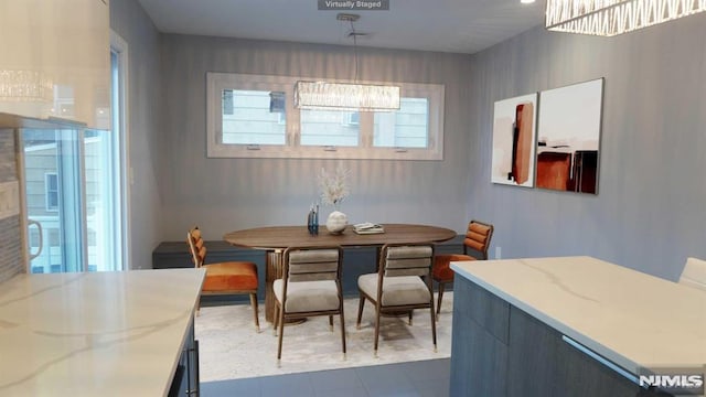 dining space with a notable chandelier and dark tile patterned flooring