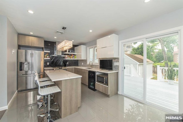 kitchen featuring stainless steel appliances, decorative light fixtures, tasteful backsplash, light tile patterned floors, and a kitchen island