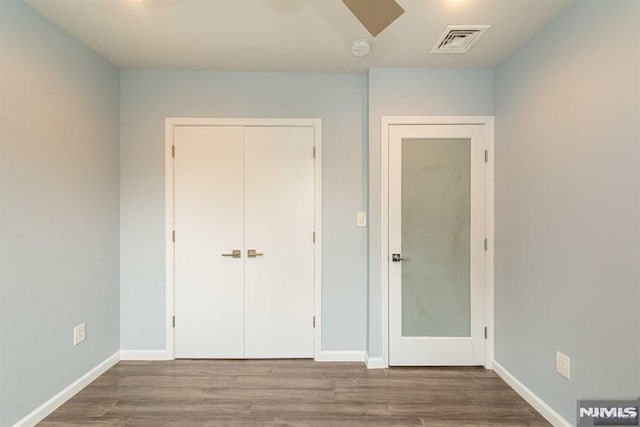 unfurnished bedroom featuring wood-type flooring, a closet, and ceiling fan