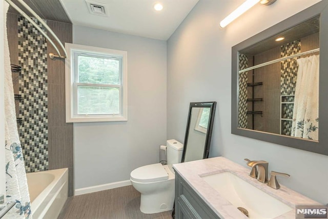 full bathroom featuring shower / bath combo, hardwood / wood-style flooring, vanity, and toilet