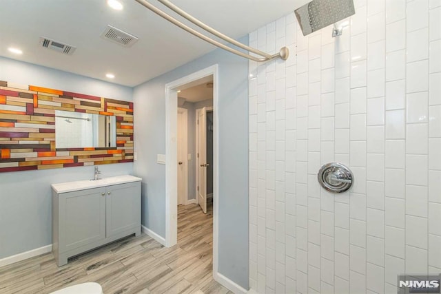 bathroom featuring walk in shower, hardwood / wood-style floors, and vanity