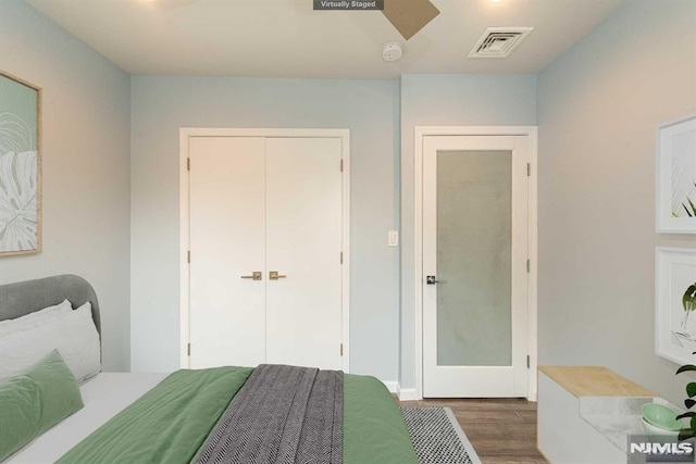 bedroom with dark wood-type flooring and a closet