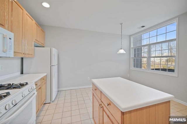 kitchen featuring white appliances, decorative light fixtures, light brown cabinetry, and a kitchen island