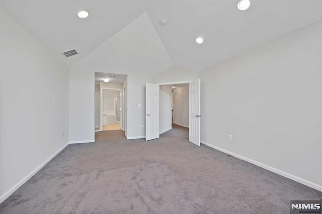 unfurnished bedroom featuring lofted ceiling and dark carpet