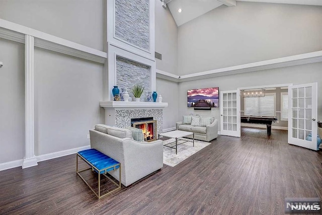 living room featuring a tile fireplace, high vaulted ceiling, and french doors