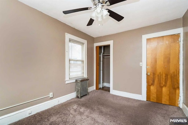 unfurnished bedroom featuring ceiling fan, carpet flooring, and radiator