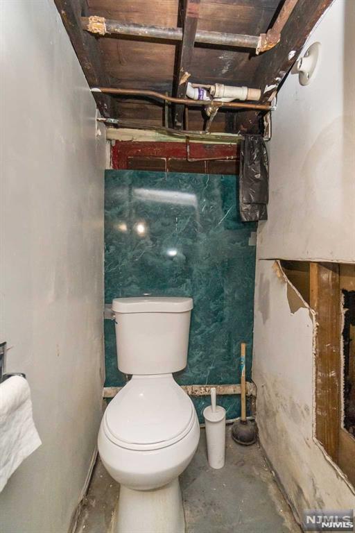 bathroom with concrete floors and toilet