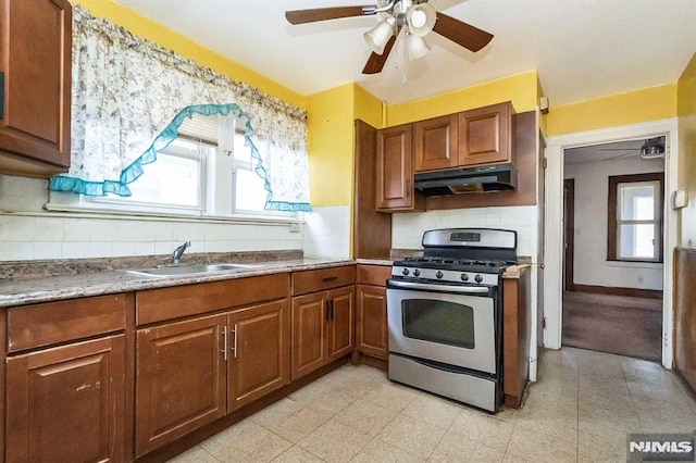 kitchen featuring sink, decorative backsplash, a wealth of natural light, and stainless steel gas range