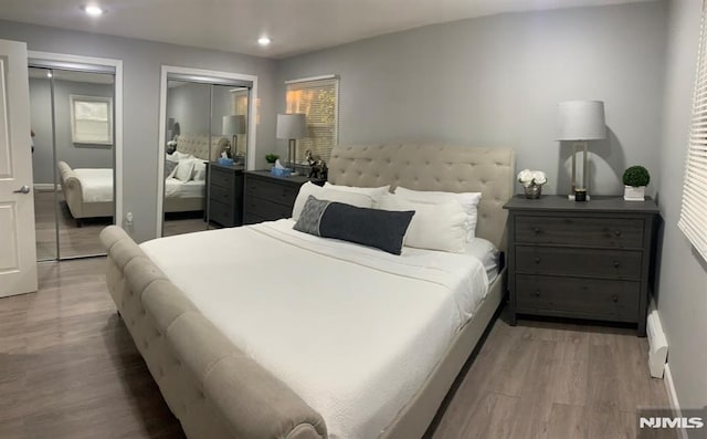 bedroom featuring two closets and hardwood / wood-style floors