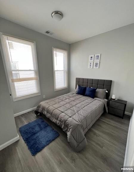 bedroom with dark wood-type flooring