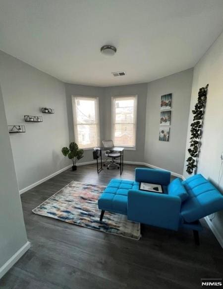 sitting room with dark wood-type flooring