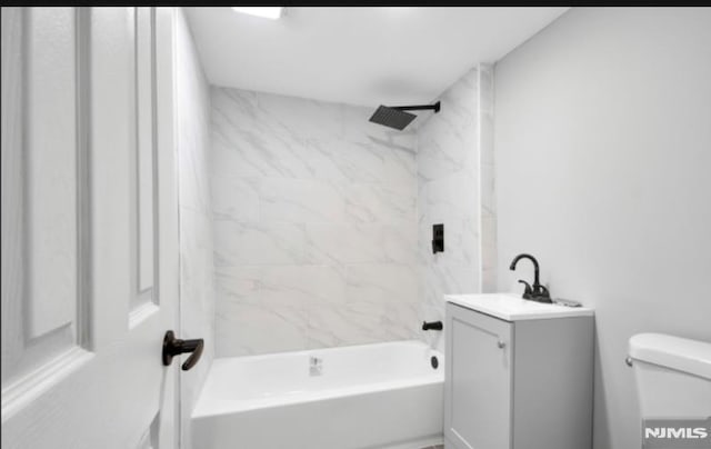 full bathroom with toilet, vanity, and tiled shower / bath combo