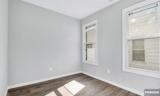 unfurnished room with dark wood-type flooring