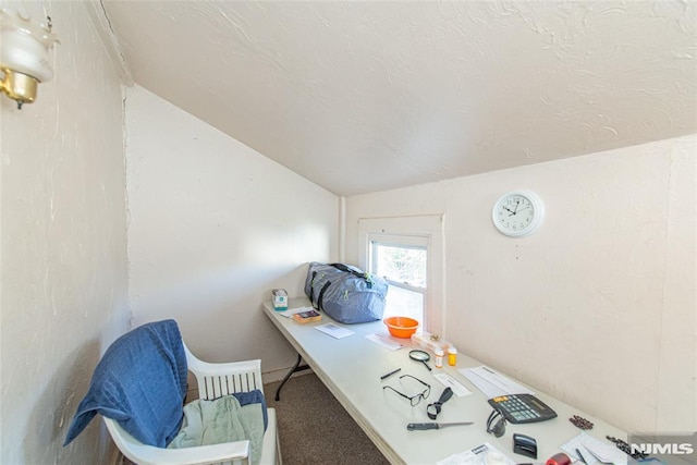 carpeted office space featuring vaulted ceiling