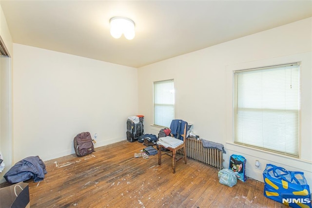 living area featuring dark wood-type flooring and radiator heating unit