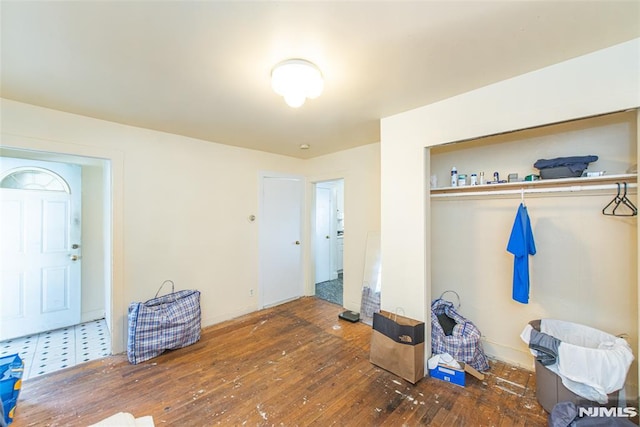 bedroom with dark hardwood / wood-style flooring and a closet