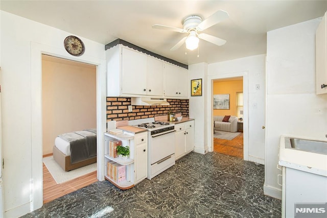 kitchen featuring ceiling fan, white cabinetry, backsplash, and white range with gas stovetop