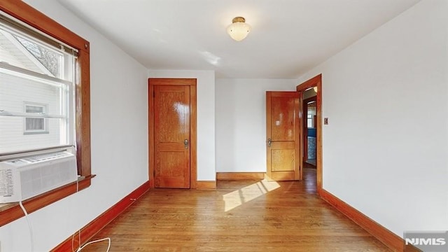 hall with light hardwood / wood-style flooring and cooling unit