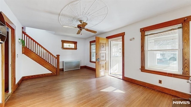 interior space featuring hardwood / wood-style floors, radiator heating unit, and ceiling fan