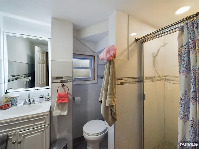 bathroom with a shower with door, vanity, and toilet