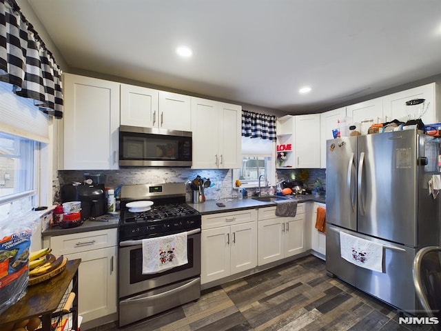 kitchen with appliances with stainless steel finishes, white cabinetry, and plenty of natural light