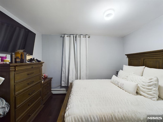 bedroom with baseboard heating and dark wood-type flooring