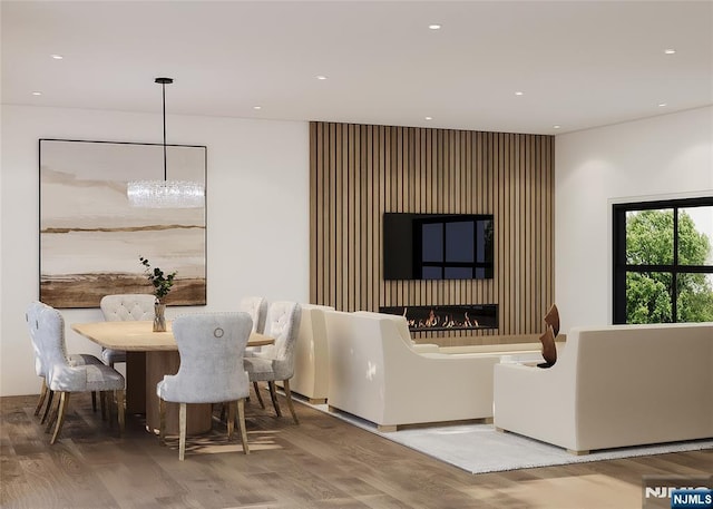 dining area with a lit fireplace, wood finished floors, and recessed lighting