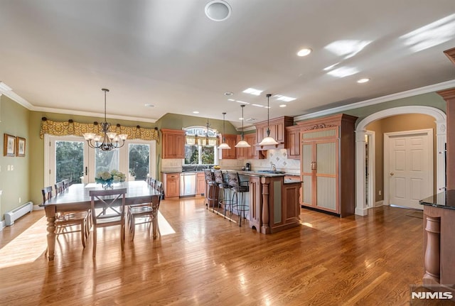 kitchen with stainless steel dishwasher, a baseboard radiator, pendant lighting, and a center island