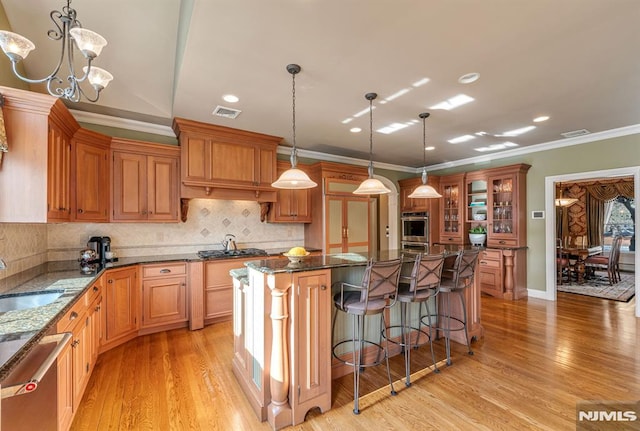 kitchen with a chandelier, stainless steel appliances, crown molding, pendant lighting, and a kitchen island