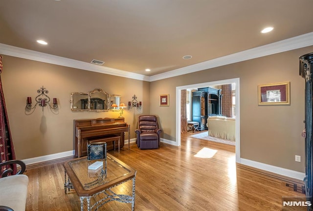 living room with wood-type flooring and ornamental molding