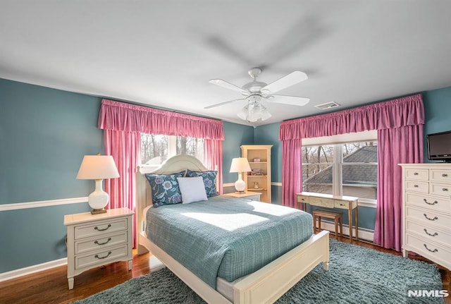 bedroom featuring baseboard heating, ceiling fan, and dark hardwood / wood-style floors